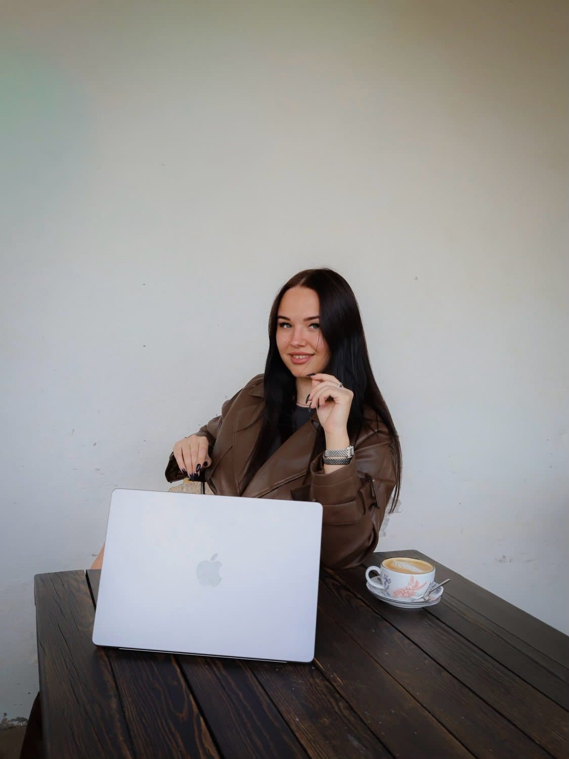RORA Beauty at a wooden table with a laptop and a cup of coffee